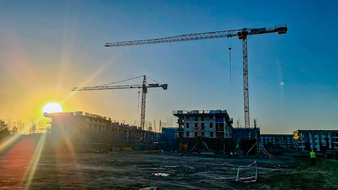 Tres grúas torre Liebherr arrendadas por Grúas Cono Sur en una obra de edificación en Santiago al atardecer