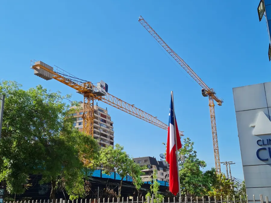 Dos grúas torre Liebherr flat-top en una obra de Santiago junto a la bandera de Chile