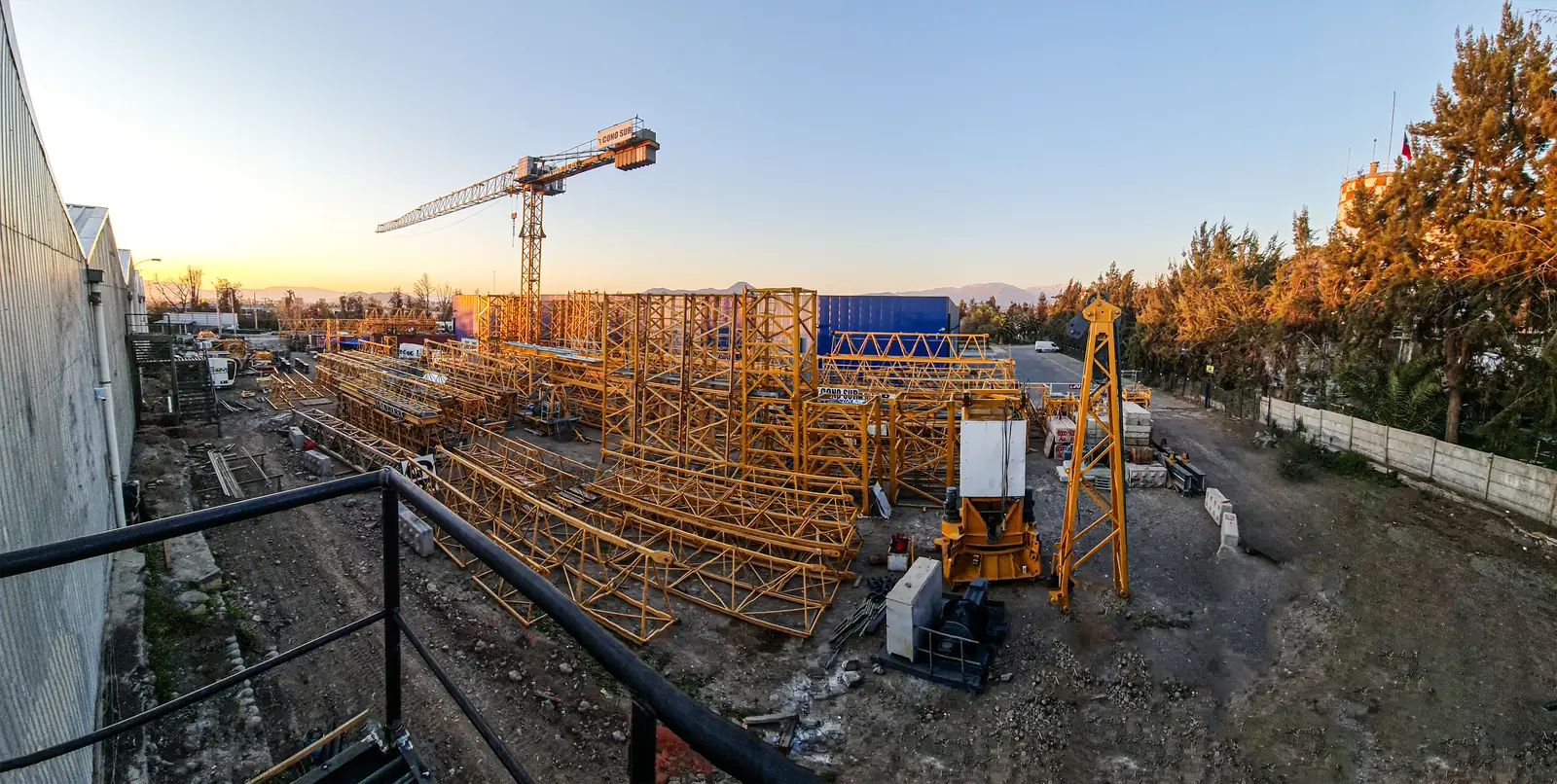 Centro de operaciones de Grúas Cono Sur en Peñalolén con tramos de grúas torre Liebherr al atardecer